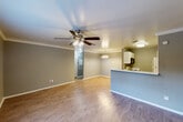 Located at 16700 Golf Club Dr, Unit 135 in Crosby, TX, this one-bedroom, one-bathroom unit offers a functional and well-appointed single-story layout. The open-concept living and dining area features wood-look laminate flooring, crown molding, and a ceiling fan with light fixture, creating a bright and comfortable atmosphere. A large window in the living room allows natural light to fill the space and offers a view of the surrounding greenery outside.

The kitchen is equipped with white cabinetry, a marble-look quartz countertop peninsula with an integrated sink, and a full-size refrigerator. The peninsula provides a natural division between the kitchen and the adjoining dining area, which is accented by an elegant chandelier and matching crown molding.

The bedroom is a comfortable, carpeted retreat featuring a ceiling fan, neutral-toned walls, and a window that brings in natural light. The full bathroom includes a quartz vanity countertop with an undermount sink, a framed mirror, white cabinetry, and a combined shower/tub enclosure. Wood-look flooring extends throughout the bathroom, tying the space together cohesively. Overall, the unit presents a clean, move-in ready interior with consistent finishes throughout.