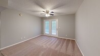 Located at 900 Brookhill Cir in Pell City, Alabama, this single-story, three-bedroom, two-bathroom home offers a functional and comfortable layout. The galley-style kitchen features white cabinetry, dark granite-style countertops, and wood-look flooring that extends into the hallway, creating a cohesive flow through the main living areas. The kitchen connects seamlessly to the rest of the home via a central hallway. The living room is carpeted and includes a ceiling fan with light fixture, along with French doors that open to a covered balcony overlooking a lush, wooded backdrop of pine trees — a standout natural feature of the property. Each of the three bedrooms is finished with plush carpeting, neutral-toned walls, and ceiling fans, offering a calm and restful atmosphere. The bedrooms include closets and windows that bring in natural light. The two full bathrooms are well-appointed, each featuring a tub-shower combination, with one bath offering a dark granite-topped vanity with a large mirror and overhead lighting. Textured ceilings are consistent throughout the home, adding a classic finish. The serene, tree-lined setting provides a sense of privacy and connection to nature.