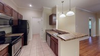 Located at 3150 Skinner Mill Rd in Augusta, Georgia, this single-floor home offers a well-designed layout that balances comfort and functionality. The open-concept living and kitchen area serves as the heart of the home, featuring warm hardwood-style flooring, crown molding, and ceiling fan fixtures that enhance the bright, airy atmosphere. The kitchen is equipped with rich dark cabinetry, granite-style countertops, stainless steel appliances including a microwave and refrigerator, a black electric range, and a built-in dishwasher. A peninsula with pendant lighting provides additional counter space and separates the kitchen from the living area. Light tile flooring carries through the kitchen and wet areas, while plush carpeting adds warmth to the bedrooms. Each bedroom includes a ceiling fan with light kit, neutral-toned walls, and windows dressed with white blinds that allow natural light to filter in. The primary bathroom features a soaking tub and tile flooring, while a secondary bathroom offers a full tub-shower combination. A dedicated laundry area and ample closet space round out the practical features of this well-appointed home.