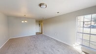 Located at 5001 Pecan Acres Street in Lake Charles, Louisiana, this single-story home offers a functional and comfortable layout across two bedrooms and two bathrooms. The interior features neutral-toned walls throughout, complemented by soft carpeting in the living and bedroom areas, creating a cohesive and understated aesthetic.

The living room is a generously proportioned space illuminated by a decorative chandelier and a flush-mount ceiling fixture, with clean white trim and easy access to the rest of the home via a central hallway. The kitchen is equipped with warm oak cabinetry, a double stainless steel sink, light-toned countertops, a dishwasher, and durable wood-look vinyl flooring, providing a practical and efficient workspace.

Both bedrooms are carpeted and bright, benefiting from natural light streaming through windows fitted with blinds. The primary bedroom features a ceiling fan with integrated lighting and multiple windows that enhance its airy feel. The second bedroom also includes a ceiling fan and a pendant light fixture. A dedicated laundry room and two closets add to the home's organizational convenience.

The two bathrooms include a tub-shower combination, a single vanity with wood cabinetry, and wood-look flooring, maintaining the consistent design language found throughout the home.