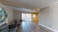 Located at 24900 Santa Clara St in Hayward, California, this single-floor unit offers a thoughtfully laid-out living space with a clean, modern aesthetic throughout. The living area is a standout feature, showcasing warm hardwood-style plank flooring that extends across the open floor plan. Large sliding glass doors with vertical blinds flood the space with natural light and provide direct access to an outdoor area, while a second window further enhances the bright, airy atmosphere. Exposed ceiling beams add a subtle architectural detail, and the neutral wall tones create a versatile backdrop for any furnishing style. Adjacent to the living area, the dining and kitchen zone is equipped with white cabinetry, a dark refrigerator, wood-tone countertops, and a ceiling fan with integrated lighting, lending a functional yet stylish feel to the space. The bedroom is carpeted for comfort, features a sun-filled window with horizontal blinds, and offers a peaceful, understated retreat. The full bathroom is well-appointed with a white vanity featuring shaker-style cabinetry, a single-basin sink, a rectangular mirror, and a tiled shower-tub combination, all finished in a cohesive neutral palette. Overall, the unit presents a refreshed, move-in-ready living environment in a convenient Hayward location.