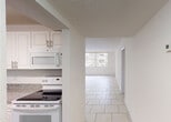 Located at 9357 SW 77th Ave in Miami, FL, this single-floor residence offers a clean, functional layout designed for comfortable living. The interior is finished with a combination of light ceramic tile flooring throughout the main living areas and kitchen, while the bedroom features warm wood-look vinyl plank flooring, providing a clear distinction between spaces.

The kitchen is well-appointed with white shaker-style cabinetry offering generous storage, granite-patterned countertops, a stainless sink, and white appliances including a built-in microwave and electric range. It opens toward the main living area, creating an accessible flow between cooking and living spaces.

The living area is bright and open, benefiting from large windows fitted with vertical blinds that allow ample natural light to filter in. A ceiling fan is installed overhead, a practical feature well-suited to Miami's warm climate. Sliding glass doors in one room provide direct access to an outdoor area, further enhancing the connection to the exterior.

The bedroom is generously proportioned and includes dual closets with louvered bifold doors, providing substantial storage. An adjacent bathroom features a granite-topped vanity. Throughout the space, white walls, textured ceilings, and neutral finishes contribute to a bright, airy ambiance that is both easy to maintain and straightforward to personalize.