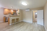 Located at 2636 Newhall St in Santa Clara, California, this single-floor, 2-bedroom, 1-bathroom home offers a thoughtfully designed layout with modern finishes throughout. Light wood-tone flooring flows seamlessly across the entire space, lending warmth and visual continuity to every room.

The kitchen is a standout feature, equipped with honey-toned wood cabinetry, light stone countertops, stainless steel appliances including a dishwasher and refrigerator, and a peninsula breakfast bar with pendant lighting — ideal for casual dining or entertaining. A wall-mounted mini-split unit provides efficient climate control in the main living area.

The spacious primary bedroom is generously proportioned, featuring a wide mirrored sliding-door closet, a large window with sheer coverings that invite natural light, and neutral warm-toned walls that create a calm, inviting atmosphere. The second bedroom offers built-in shelving and easy access to the rest of the home.

The bathroom is cleanly finished with a tiled tub-shower combo enclosed in a glass sliding door, a white vanity with ample storage, and a window for natural ventilation. A stacked washer and dryer unit is conveniently located within the bathroom. This well-maintained home combines efficient use of space with contemporary finishes throughout.