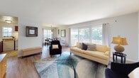 Located at 2250 N Triphammer Rd in Lansing, NY, this single-floor residence offers a thoughtfully designed layout that balances comfort and functionality. The expansive living room is a highlight of the home, featuring large picture windows and sliding glass doors that flood the space with natural light and provide direct access to a private balcony overlooking lush greenery. Light wood-tone flooring runs throughout the main living areas, complementing the neutral color palette.

The living room flows seamlessly into the dining area, which is anchored by a stylish pendant light fixture and framed by windows that enhance the sense of openness. The kitchen features rich dark cabinetry with granite-style countertops, tile flooring, and white appliances, offering a functional and efficient workspace.

The bedrooms are carpeted for comfort and fitted with generous natural light through well-placed windows. Each room provides ample space for furnishings and storage. The bathroom is finished with classic white subway tile surrounding a full soaking tub, a wood-toned vanity, and a mirrored medicine cabinet, creating a clean and timeless aesthetic. Throughout the home, neutral tones and consistent finishes create a cohesive and welcoming atmosphere.
