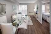 Located at 151 Beecroft Ave in Toronto's North York neighbourhood, this thoughtfully updated unit offers a cohesive, single-floor layout designed for comfortable urban living. The open-concept living and dining area forms the heart of the space, finished with warm hardwood-style flooring and neutral tones throughout. A large sliding glass door floods the living room with natural light and leads to a private balcony overlooking the surrounding cityscape, providing an elevated urban outlook.

The kitchen is positioned adjacent to the living area and features white cabinetry, stainless steel appliances including a refrigerator, electric range, and built-in microwave, along with a light-toned countertop with an undermount sink. The peninsula-style layout creates a natural division between the kitchen and living space while maintaining an open feel.

The bedroom is a calm, well-proportioned retreat with a window offering city views, hardwood-style flooring, and a built-in sliding-door closet providing ample storage. The bathroom is clean and functional, featuring a full tub-shower combination with tiled surround, a vanity with countertop sink, and neutral finishes that complement the overall palette of the unit.