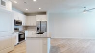 Located at Broadstone in Houston, TX, this 1-bedroom, 1-bathroom unit offers a thoughtfully designed open-concept layout with contemporary finishes throughout. Light wood-style flooring flows seamlessly across the entire living space, creating a bright and cohesive aesthetic.

The kitchen serves as the centerpiece of the open living area, anchored by a central island with a granite countertop and an undermount sink. White shaker-style cabinetry, a classic subway tile backsplash, and a full suite of stainless steel appliances — including a French door refrigerator with ice and water dispenser, a wall oven, and a built-in microwave — complete the modern kitchen design. Recessed lighting illuminates the space efficiently.

The living area flows naturally from the kitchen, offering an open and airy feel. The bedroom is a comfortable, well-proportioned room featuring light-toned walls, a window with blinds that brings in natural light, and continuity of the wood-style flooring. A dedicated walk-in closet provides multi-tier wire shelving for organized storage.

The bathroom is finished with a granite-topped vanity, white cabinetry, an undermount sink, and a glass-enclosed shower with elegant marble-style tile surround. Clean lines and neutral tones maintain a polished, modern look throughout the entire unit.