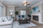 Located in Orem, Utah, this 2-bedroom, 2-bathroom single-floor residence offers a thoughtfully designed layout that makes efficient use of its space. The living room serves as the heart of the home, featuring crown molding, a textured ceiling, and a classic white-mantled fireplace with tile surround. Natural light filters in through a large window with blinds, creating a warm and inviting atmosphere complemented by plush carpeting throughout.

The kitchen is well-equipped and visually striking, with rich warm-toned cabinetry, light stone-finish countertops, a central island with bar seating, and a full suite of white appliances including a dishwasher, range, microwave, and refrigerator. An adjacent dining area provides convenient space for meals and entertaining.

Both bedrooms offer carpeted floors and neutral walls, fostering a calm and restful environment. The primary bedroom provides a comfortable, private retreat, while the second bedroom includes additional storage furniture and direct hallway access.

The two bathrooms are finished consistently, each featuring warm wood cabinetry, stone-finish countertops, wood-look vinyl flooring, and a full tub-shower combination. A hallway and closet complete the floorplan, adding practical storage and connectivity throughout the home.