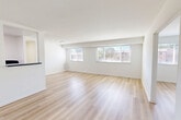 Located at 5734 Backlick Rd in Springfield, Virginia, this well-appointed 2-bedroom, 1-bathroom residence offers a practical and comfortable single-floor layout. The spacious living room is a standout feature, bathed in natural light through a wide bank of windows and finished with light-toned hardwood-style flooring that extends throughout the main living areas, creating a clean and cohesive aesthetic with crisp white walls throughout.

The galley-style kitchen is efficiently designed with white cabinetry, dark stone-look countertops, a gas range, and a refrigerator — providing a functional cooking space with a classic contrast of black appliances against bright cabinetry. Adjacent dining and living areas allow for flexible use of the open layout.

Both bedrooms are carpeted for comfort, with the generously sized primary bedroom featuring a ceiling fan and direct access to a dedicated closet. Additional bedrooms and a den provide versatile options for living or workspace needs. The unit benefits from four closets in total, offering substantial storage throughout.

The bathroom presents a stylish design with bold navy subway tile wainscoting, a white vanity, and light wood-style flooring. A utility room and additional storage round out the functional offerings of this well-organized residence in Springfield, VA.