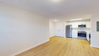 This single-floor, 2-bedroom, 2-bathroom unit offers a well-organized layout with a clean, modern aesthetic throughout. The open-concept living and kitchen area is anchored by light wood-tone flooring that extends across the common spaces, creating a bright and cohesive feel. The kitchen is well-appointed with white shaker cabinetry, white subway tile backsplash, light quartz countertops, and a full suite of stainless steel appliances including a refrigerator, range, microwave, and dishwasher. A skylight above the kitchen adds an additional source of natural light.

The living area flows directly from the kitchen and features a double-door closet, providing convenient storage. Both bedrooms are carpeted and receive natural light through blinded windows. The primary bedroom is distinguished by vaulted ceilings and an arched window that floods the room with light, along with a ceiling fan for added comfort. The second bedroom also features a ceiling fan. A dedicated walk-in closet with built-in shelving and hanging rods offers ample storage. Both bathrooms feature white vanities with light countertops, wood-tone flooring, and tiled shower surrounds, maintaining the unit's consistent, clean design palette.