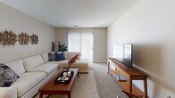 This single-floor residence offers a thoughtfully designed layout that balances functionality and comfort across its main living spaces. The kitchen is a standout feature, showcasing rich dark cabinetry paired with light granite-style countertops, stainless steel appliances including a refrigerator, dishwasher, microwave, and range, plus a built-in wine rack accent and durable hardwood-style flooring. A double basin sink and ample upper and lower cabinet storage make this kitchen as practical as it is visually appealing.

The living room provides a comfortable, open atmosphere with plush carpeting, neutral-toned walls, and a sliding glass door that welcomes natural light. The space is well-suited for both relaxing and entertaining.

Both bedrooms feature soft carpeting, ceiling fans with light fixtures, and generous closet space. Natural light filters through windows dressed with blinds and curtain panels, creating a warm and restful environment.

The two bathrooms are finished with neutral tones and brushed nickel fixtures. One bathroom features a full soaking tub with an overhead shower, while the other offers a walk-in shower with sliding glass doors — providing convenient options for residents.