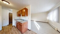 This 610 square foot single-story residence in Saint Paul, Minnesota offers a practical layout with two bedrooms and one bathroom. The property's standout feature is its expansive primary bedroom, measuring an impressive 370 square feet - over half the total floor space. 

The interior is characterized by a neutral color palette, with white walls and ceilings creating a bright, airy atmosphere. Wall-to-wall carpeting in a light gray hue covers the floors throughout, providing comfort and consistency. Large windows in the bedrooms allow for abundant natural light, enhancing the sense of spaciousness.

The home includes two hallways for easy navigation between rooms. Built-in storage solutions are evident, with one bedroom featuring floor-to-ceiling closet doors, maximizing space efficiency. Baseboard heating units are visible, ensuring comfort during Minnesota's cold winters.

While compact, the layout appears well-designed for functionality. The rooms are of a reasonable size, with the living areas and bedrooms offering flexibility for various furniture arrangements. The overall aesthetic is clean and low-maintenance, ideal for those seeking a simple, no-fuss living space in an urban setting.