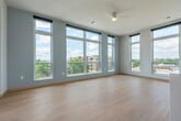 Located at 3900 Monona Dr in Madison, WI, this well-appointed 4-bedroom, 2-bathroom single-floor residence offers a thoughtfully designed open layout with over 2,100 square feet of living space. Light wood-look flooring runs throughout, complementing the clean, contemporary aesthetic found in every room.

The combined kitchen and living area serves as the heart of the home, featuring a striking kitchen with white shaker cabinetry, gold and mixed-metal hardware, a marble-look tile backsplash, stainless steel appliances including a wall oven and induction cooktop, and a large white quartz island with a double undermount sink. Pendant lighting and oversized windows flood the space with natural light and offer views of the surrounding neighborhood.

The four bedrooms are bright and well-proportioned, each featuring large windows with roller shades and ceiling fans. One bedroom opens directly onto a private balcony, while another offers sweeping views that include a glimpse of water. Both bathrooms are finished with white quartz countertops, shaker-style vanities with gold-accented hardware, modern light fixtures, and large mirrors. One bathroom includes a glass-enclosed shower. Connecting hallways are clean and well-lit with recessed lighting, and a dedicated closet provides additional storage. The overall ambiance is modern, light-filled, and move-in ready.
