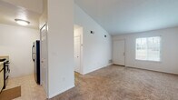 Located at 1975 Valleybrook Rd in Streetsboro, Ohio, this single-floor home offers a straightforward, functional layout designed for comfortable everyday living. The living area is a standout feature, characterized by soaring vaulted ceilings that create an open, airy atmosphere. Neutral-toned carpet runs throughout the main living and bedroom spaces, providing warmth underfoot, while natural light filters in through multiple windows. A front entry door with an adjacent window further brightens the main living area.

The kitchen is equipped with essential appliances, including a gas range, dishwasher, and refrigerator. Wood-toned upper cabinetry pairs with light countertops and a double stainless steel sink, complemented by tile flooring for easy maintenance. A pendant light fixture illuminates the adjacent dining area, which also benefits from vaulted ceilings and a window overlooking the outdoors.

The bedrooms are carpeted and well-proportioned, each featuring windows that allow natural light to fill the rooms. The primary bedroom includes access to a walk-in closet as well as an additional closet, offering generous storage. The bathroom includes a tub-shower combination, toilet, and wood-look flooring, finished in a clean, neutral palette consistent with the rest of the home.