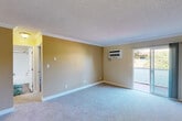 Located at 1575 Tenaka Pl in Sunnyvale, California, this single-story 3-bedroom, 2-bathroom home offers a well-organized and functional layout. The living room greets you with soft carpeting, warm neutral-toned walls, crown molding, a textured ceiling, and a wall-mounted AC unit. A sliding glass door floods the space with natural light and provides direct access to an outdoor area with pleasant greenery views. The front entryway features durable wood-look flooring that transitions smoothly into the carpeted living area.

The kitchen is a standout feature, showcasing crisp white shaker cabinetry, stone-look countertops, a decorative tile backsplash, and wood-look flooring. A full suite of stainless steel appliances — including a refrigerator, range, microwave, and dishwasher — completes the space, making it both stylish and practical.

The bedrooms are carpeted and bright, each featuring mirrored sliding closet doors and windows that invite natural light and garden views. Baseboard heaters provide consistent warmth throughout.

The two bathrooms are tastefully updated: one features a full soaking tub with a shower, and the other a glass-enclosed walk-in shower. Both include white vanity cabinetry, stone-look countertops, and wood-look flooring, lending a clean, modern aesthetic throughout.