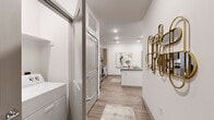 This thoughtfully designed single-floor residence offers 2 bedrooms and 2 bathrooms within a efficiently utilized floor plan. The open-concept layout connects the living room, dining area, and kitchen, creating a cohesive and functional living space. Wood-look plank flooring flows throughout, contributing to a warm yet contemporary aesthetic.

The kitchen serves as a central hub, featuring a large island with seating, quartz-style countertops, a subway tile backsplash, taupe cabinetry extending to the ceiling, and stainless steel appliances including a refrigerator, range, and microwave. Recessed lighting illuminates the space effectively.

The living room is bright and open, benefiting from multiple windows that invite natural light. The primary bedroom is a comfortable retreat with a ceiling fan, natural light from a large window, and dedicated closet space. The second bedroom features a distinctive teal accent wall, adding a pop of color to the neutral palette.

Both bathrooms are finished with wood-look flooring and modern cabinetry. One bathroom includes a glass-enclosed walk-in shower with a single vanity, while the second features a full tub-shower combination with upper cabinetry. Two hallways and two closets provide practical storage throughout the unit.