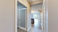 Located on an upper floor at 15 Maple Ave in Barrie, Ontario, this well-appointed 2-bedroom, 1-bathroom unit offers a thoughtfully designed open-concept layout with modern finishes throughout. The combined living and dining area is bright and airy, featuring light hardwood-style flooring and a striking gold-toned chandelier that adds an elegant touch. Large windows frame sweeping city and treetop views, filling the space with natural light.

The kitchen is a standout feature, equipped with rich dark wood cabinetry, a mosaic tile backsplash, stainless steel appliances including a full-size refrigerator, range, and microwave, as well as a peninsula with a light countertop — ideal for casual dining or meal prep.

Both bedrooms are generously proportioned. The primary bedroom features plush carpeting and a large window with elevated city views, while the second bedroom offers light hardwood-style flooring and its own outdoor outlook. A dedicated closet provides organized storage.

The bathroom is clean and contemporary, finished with marble-look tile flooring, a full soaker tub with shower, and a dark wood vanity with a light countertop. The unit also includes a dedicated laundry area, completing this practical and polished urban residence.