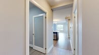 Located on an upper floor at 15 Maple Ave in Barrie, Ontario, this well-appointed 2-bedroom, 1-bathroom unit offers a thoughtfully designed open-concept layout with modern finishes throughout. The combined living and dining area is bright and airy, featuring light hardwood-style flooring and a striking gold-toned chandelier that adds an elegant touch. Large windows frame sweeping city and treetop views, filling the space with natural light.

The kitchen is a standout feature, equipped with rich dark wood cabinetry, a mosaic tile backsplash, stainless steel appliances including a full-size refrigerator, range, and microwave, as well as a peninsula with a light countertop — ideal for casual dining or meal prep.

Both bedrooms are generously proportioned. The primary bedroom features plush carpeting and a large window with elevated city views, while the second bedroom offers light hardwood-style flooring and its own outdoor outlook. A dedicated closet provides organized storage.

The bathroom is clean and contemporary, finished with marble-look tile flooring, a full soaker tub with shower, and a dark wood vanity with a light countertop. The unit also includes a dedicated laundry area, completing this practical and polished urban residence.