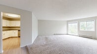 Located at 301 Shelard Pkwy in St. Louis Park, MN, this single-floor residence offers a well-planned layout across two bedrooms and two bathrooms. The expansive living room is a standout feature, finished with soft wall-to-wall carpeting, a textured ceiling, and a large window that invites abundant natural light and views of the surrounding greenery. Baseboard heating runs along the perimeter, ensuring consistent comfort throughout.

The kitchen is outfitted with white cabinetry, granite-style countertops, stainless steel appliances including a refrigerator and dishwasher, and light wood-look flooring that extends into the hallway. Both bathrooms echo the kitchen's aesthetic with matching white vanities, granite countertops, and brushed nickel fixtures.

The generously sized primary bedroom features dual windows overlooking lush outdoor scenery and includes baseboard heating. The second bedroom is carpeted and equipped with a full-width sliding closet, offering practical storage. Neutral, light-toned walls throughout create a clean, cohesive atmosphere. The overall layout is functional and bright, making efficient use of the available space.