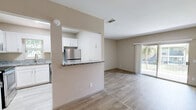 Located at 4301 Confederate Point Rd in Jacksonville, FL, this well-appointed one-bedroom, one-bathroom unit offers a thoughtful single-floor layout with modern finishes throughout. Light-toned wood-look flooring runs continuously through the space, creating a cohesive and clean aesthetic.

The kitchen is a standout feature, boasting crisp white shaker cabinets, granite countertops, and a full suite of stainless steel appliances including a range, over-the-range microwave, refrigerator, and dishwasher. A pass-through counter connects the kitchen to the combined dining and living area, enhancing the open feel. An in-unit washer/dryer combo is conveniently integrated into the kitchen space. A window above the sink brings in natural light.

The living room is bright and open, benefiting from a sliding glass door that leads to a private balcony overlooking lush greenery and water views — a serene backdrop that fills the room with natural light.

The spacious primary bedroom also features a sliding glass door with outdoor access and views, accompanied by a generous walk-in closet. The full bathroom is finished with granite countertops, white cabinetry, a large mirror, and a tub/shower combination. Two hallways and additional closets provide ample storage throughout the unit.