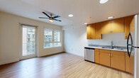 Located at 1455 Kettner Boulevard in San Diego's Little Italy neighborhood, this two-bedroom, one-bathroom residence offers a practical and well-appointed layout across a single floor. Light wood-style flooring flows throughout the main living and kitchen areas, lending a clean, contemporary feel to the space.

The open kitchen is equipped with warm-toned wood cabinetry, granite-style countertops, and a full suite of stainless steel appliances including a refrigerator, range, built-in microwave, and dishwasher. It opens directly into the living area, which features recessed lighting, a ceiling fan, and a large window that invites natural light and urban views. A balcony provides additional outdoor access.

A long, well-lit hallway connects the main living area to the private quarters. Both bedrooms are carpeted and offer a quiet retreat, with the primary bedroom featuring mirrored sliding closet doors that enhance the sense of space. Natural light enters through windows with views of the surrounding cityscape.

The full bathroom is finished with wood-look tile flooring, a warm wood vanity with granite-style countertops, and a tub-shower combination with white tile surround and brushed nickel fixtures. The overall design is clean, functional, and well-suited for urban living in one of San Diego's most vibrant neighborhoods.