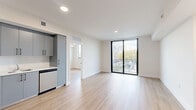 Located at 1559 Northwest 15th Street Road in Miami, FL, this modern 1-bedroom, 2-bathroom unit offers a thoughtfully designed layout with clean lines and contemporary finishes throughout. Light wood-look flooring flows seamlessly across the entire space, creating a bright, cohesive aesthetic.

The open-concept kitchen and living area serves as the heart of the unit. The kitchen features sleek gray cabinetry with black hardware, white quartz countertops, a subway tile backsplash, and a full suite of stainless steel appliances including a range, dishwasher, refrigerator, and microwave. The adjacent living area is bathed in natural light from large floor-to-ceiling sliding glass doors that open to a private balcony overlooking the Miami cityscape and lush tree canopy.

The bedroom is a comfortable, well-proportioned retreat with a large window framing outdoor views, a ceiling fan, and access to a dedicated walk-in closet equipped with wire shelving for organized storage. Both bathrooms are finished with large-format beige tile surrounding a full soaking tub and shower combination, paired with neutral tile flooring for a clean, modern look. The unit's bright white walls and recessed lighting throughout contribute to its fresh, move-in-ready appeal.