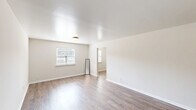 Located at 800 Walker Ave in Rossville, GA, this single-floor, 2-bedroom, 1-bathroom unit offers a clean and functional layout designed for comfortable everyday living. The open living room features light wood-tone vinyl plank flooring, neutral wall tones, and windows that allow natural light to fill the space, creating a bright and airy atmosphere. A hallway connects the living area to the rest of the unit, providing a logical flow throughout.

The kitchen is a standout feature, showcasing a U-shaped layout with distinctive blue lower cabinets, gray upper cabinetry, a white tile backsplash, and light countertops. A white electric range, double sink, and full-size refrigerator complete the space, while wood-look flooring and a window add warmth and practicality.

Both bedrooms are carpeted and finished with neutral paint, clean white trim, and windows framing views of surrounding greenery, lending a calm and restful ambiance. The primary bedroom offers a comfortable footprint suited for a full bedroom setup.

The bathroom includes a combination tub and shower with tiled surround and chrome fixtures, complemented by neutral wall tones and classic finishes. Throughout the unit, the consistent use of light colors and clean lines contributes to a cohesive, move-in-ready feel.