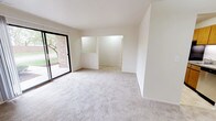 This single-story, two-bedroom, two-bathroom residence offers a thoughtful layout designed for comfortable everyday living. The spacious living area is finished with neutral-toned carpet and features a full-width sliding glass door that fills the room with natural light while providing direct access to an outdoor patio. Views of mature trees and a fenced yard are visible from this central gathering space, giving the interior a pleasant, connected feel.

The galley-style kitchen is efficiently arranged with warm oak cabinetry, laminate countertops, tile flooring, and stainless steel appliances including a refrigerator, electric range, and over-the-range microwave. A stainless steel sink completes the workspace.

Both bedrooms are carpeted and feature windows overlooking the surrounding greenery, providing natural light and outdoor views. The two full bathrooms include tile flooring, a tub-shower combination, and one bathroom features an oak vanity with ample cabinet storage beneath a well-lit mirror.

A dedicated laundry room with full-size washer and dryer hookups—with units included—adds notable convenience. Throughout, the interiors maintain a clean, neutral palette with white walls and consistent finishes, creating a bright and adaptable living environment.