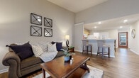 Located at 20 Bur Reed Rd in Delaware, Ohio, this single-floor residence offers a thoughtfully designed layout that balances comfort and functionality. The living room serves as the heart of the home, featuring warm hardwood-style flooring, neutral gray walls, and an open sightline to the kitchen — creating a connected, welcoming atmosphere ideal for everyday living and entertaining.

The kitchen is outfitted with light wood cabinetry, white appliances including a refrigerator, microwave, and range, and a breakfast bar with seating. A dedicated walk-in pantry provides generous shelved storage, adding notable practicality to the space.

The primary bedroom is a serene retreat with plush carpeting, a ceiling fan, and a window overlooking the outdoors. It is complemented by a spacious walk-in closet with wire shelving and a well-appointed bathroom featuring a walk-in shower and rich hardwood-style flooring. An additional bedroom also offers soft carpet and ample room.

A versatile office or flex room stands out with its dark hardwood-style flooring, ceiling fan, and sliding glass door opening to a private patio — allowing for abundant natural light and easy outdoor access.

Throughout the home, consistent use of hardwood-style and carpeted flooring, neutral tones, and clean architectural lines contribute to a cohesive, comfortable living environment.