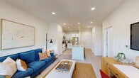 Located at 300 Commerce Ave in LaGrange, Georgia, this one-bedroom, two-bathroom unit offers a thoughtfully designed single-floor layout. The open-concept living, dining, and kitchen area forms the heart of the home, bathed in natural light from large windows with views to the outdoors. Light-toned hardwood-style flooring flows throughout, complementing the bright, white walls and recessed lighting overhead.

The kitchen is well-appointed with white shaker cabinetry featuring black hardware, granite countertops, a central island, subway tile backsplash, and a full suite of stainless steel appliances including a refrigerator, range, and built-in microwave. The living area provides a comfortable, open space with room for both lounging and dining.

The generously sized primary bedroom offers a ceiling fan, plush carpeting, and a calm, neutral palette. Three closets provide ample storage throughout the unit. Both bathrooms are finished with white cabinetry, granite-topped vanities, and tiled tub-shower combinations. A dedicated utility room houses a full-size washer and dryer, adding everyday convenience. This unit delivers a clean, modern aesthetic with functional, well-organized living spaces.