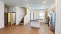 Located at 257 Mazari Ln in Venice, Florida, this contemporary two-story home is designed with a clean, modern aesthetic throughout. The main level features an open-concept layout where the living area flows seamlessly into the kitchen. The kitchen is well-appointed with light wood cabinetry, a subway tile backsplash, quartz-topped island with an undermount sink, and a full suite of stainless steel appliances including a refrigerator, range, and microwave. Light wood-look flooring runs throughout the main level, complementing the bright white walls and recessed lighting. A ceiling fan adds comfort to the living space, which receives natural light through multiple windows fitted with blinds. A carpeted staircase leads to the upper level, where the bedrooms offer plush carpet flooring and additional natural light. The primary bedroom connects to an en-suite bathroom featuring a soaking tub with tiled surround. A spacious walk-in closet with built-in shelving provides generous storage. Additional rooms on the upper level include a bedroom with easy access to a secondary bathroom. The home also includes a walk-in closet and multiple entry points. The overall ambiance is fresh, neutral, and move-in ready, well-suited to the Florida lifestyle.