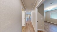 Located at 2525 Crescent Cove Dr in Evans, Colorado, this single-floor, 2-bedroom, 1-bathroom residence offers a practical and comfortable layout. Throughout the home, warm-toned wood-look flooring provides a cohesive and easy-to-maintain finish, complemented by neutral beige walls and crisp white trim and baseboards.

The living room is a highlight of the space, featuring elegant crown molding, a ceiling fan with a light fixture, and a full sliding glass door that opens to a private balcony, flooding the room with natural light and providing outdoor access.

The kitchen is positioned at the heart of the unit and connects seamlessly to the main living area. A central hallway with recessed lighting links all rooms, offering a clean and organized flow throughout the home.

The primary bedroom is generously sized and includes a sliding closet door, while the second bedroom features a window with natural light and ample floor space. Both rooms continue the warm flooring aesthetic seen throughout the home.

The bathroom is neatly finished with a white vanity cabinet, stone-look countertop, a large mirror with overhead lighting, and a standalone shower. A second vanity area with similar finishes provides additional convenience. Overall, the space presents a clean, move-in-ready environment with consistent, modern finishes.