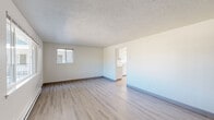 Located at 1445 SW A St in Corvallis, Oregon, this single-floor unit offers a practical and well-maintained layout ideal for comfortable everyday living. The living area is bright and open, finished with light wood-style vinyl flooring that extends throughout the main spaces. Neutral white walls and a textured ceiling contribute to a clean, airy atmosphere, while windows allow natural light to fill the room. A baseboard heating system provides warmth during cooler months. The living space connects seamlessly to the kitchen, which features white cabinetry with modern hardware, light countertops, an electric range with overhead ventilation, and a single-basin sink beneath a window. Ample upper and lower cabinet storage makes the kitchen both functional and organized. The bedroom is carpeted for added comfort and includes a window that brings in natural light, along with baseboard heating and a ceiling light fixture. The bathroom is efficiently designed, featuring a combination tub and shower with a clean white surround, a toilet, and light wood-style flooring that ties in with the rest of the unit. Throughout the space, the consistent neutral palette, updated finishes, and practical layout create a cohesive and move-in-ready living environment.