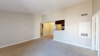 Located at 5915 Flintlock Rd in Houston, TX, this 2-bedroom, 2-bathroom unit offers a comfortable and well-organized single-floor layout. The living room is a standout space, featuring plush carpeting, vaulted ceilings that enhance the sense of openness, a wood-burning fireplace with a distinctive chevron-patterned tile surround, and a sliding glass door leading to a private balcony with outdoor views. A chandelier-lit dining area transitions seamlessly from the kitchen, creating a cohesive entertaining space. The galley-style kitchen is well-appointed with rich dark cabinetry, granite-look countertops, a stone tile backsplash, black appliances including an electric range and refrigerator, a double stainless steel sink, and wood-look tile flooring. Both bedrooms are carpeted and offer a calm, neutral palette, with the primary bedroom featuring a dedicated closet. Each bedroom is served by its own bathroom, both finished with white subway-tiled tub-shower combinations and wood-look tile floors. A walk-in closet provides additional storage. The unit maintains a clean, neutral aesthetic throughout, making it a versatile and functional home.