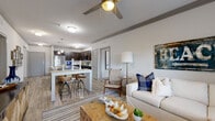 Located in Melbourne, FL, this thoughtfully designed 2-bedroom, 3-bathroom residence offers a comfortable and modern living experience across a single floor. The open-concept living and kitchen area serves as the heart of the home, featuring wood-look flooring, crown molding, and ceiling fans that enhance the bright, airy atmosphere. Large windows invite natural light throughout, with views of the surrounding landscape.

The kitchen is a standout feature, boasting dark espresso cabinetry, stainless steel appliances, pendant lighting, and a generous granite-topped island with bar seating — ideal for casual dining and entertaining. The living area flows seamlessly from the kitchen, providing a welcoming space with ample room for relaxation.

Both bedrooms are carpeted for comfort and include ceiling fans and large windows that frame outdoor views. The primary bedroom is a well-sized retreat with its own en-suite bathroom, which features a dual-sink vanity with granite countertops, a separate glass-enclosed shower, and a soaking tub with white subway tile surround. Walk-in closets with wire shelving provide generous storage. The additional bathrooms maintain the same refined design language, ensuring comfort for residents and guests alike.