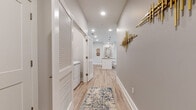 Located at 37 Glenview Dr in Cromwell, Connecticut, this single-floor residence presents a thoughtfully designed open-concept layout with modern finishes throughout. Light-toned luxury vinyl plank flooring flows seamlessly across the main living areas, anchoring a cohesive and contemporary aesthetic.

The kitchen serves as a central hub of the home, featuring a large island with granite countertops, pendant lighting, white shaker-style cabinetry, a classic subway tile backsplash, and stainless steel appliances. The kitchen opens directly to the dining and living areas, the latter accented by a textured feature wall, ceiling fan, and French doors that invite natural light and outdoor access.

A well-appointed hallway connects the main living spaces to the private quarters, and includes a dedicated laundry area with louvered bifold doors and decorative gold wall art that adds a sophisticated touch. The bedrooms are carpeted for comfort, with generous closet space and large windows that allow abundant natural light. One bedroom features a built-in desk area, ideal for a home office setup.

The bathrooms are finished with wood-look tile flooring, grey shaker vanities, white subway tile tub surrounds, and clean, neutral color palettes. The space as a whole presents a well-balanced blend of functionality and refined modern design.