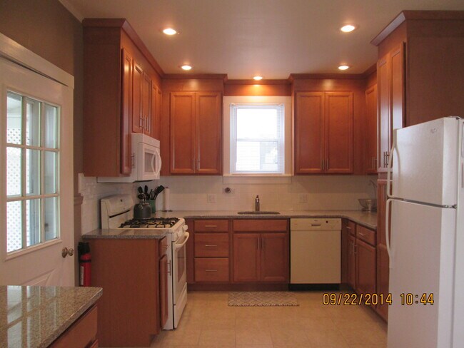 Salpicadero de azulejos tipo metro, encimera de granito, armarios Kraftmaid con cierre suave. - 972 Cherry St