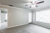 This single-floor residence offers a functional and comfortable layout with a variety of thoughtful features throughout. The galley-style kitchen is well-equipped with stainless steel appliances, including a range, over-the-range microwave, refrigerator, and dishwasher. White shaker-style cabinetry provides ample storage, while wood-look flooring adds warmth and durability to the space.

The living area is bright and welcoming, featuring plush carpet, crown molding, a ceiling fan with light fixture, and a large window that allows natural light to fill the room. A door provides direct outdoor access, extending the living space further. An additional carpeted room, also equipped with a ceiling fan, features a sliding glass door and serves well as a bedroom or secondary living space. Another bedroom includes a walk-in closet with built-in shelving, offering generous storage.

The full bathroom is clean and functional, featuring a tub-shower combination, a white vanity with a dark countertop, and wood-look flooring. A dedicated in-unit laundry closet with shelving above the washer and dryer adds everyday convenience. Neutral tones and consistent finishes throughout create a cohesive and move-in-ready environment.
