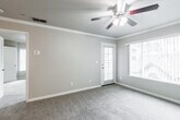 This single-floor residence offers a functional and comfortable layout with a variety of thoughtful features throughout. The galley-style kitchen is well-equipped with stainless steel appliances, including a range, over-the-range microwave, refrigerator, and dishwasher. White shaker-style cabinetry provides ample storage, while wood-look flooring adds warmth and durability to the space.

The living area is bright and welcoming, featuring plush carpet, crown molding, a ceiling fan with light fixture, and a large window that allows natural light to fill the room. A door provides direct outdoor access, extending the living space further. An additional carpeted room, also equipped with a ceiling fan, features a sliding glass door and serves well as a bedroom or secondary living space. Another bedroom includes a walk-in closet with built-in shelving, offering generous storage.

The full bathroom is clean and functional, featuring a tub-shower combination, a white vanity with a dark countertop, and wood-look flooring. A dedicated in-unit laundry closet with shelving above the washer and dryer adds everyday convenience. Neutral tones and consistent finishes throughout create a cohesive and move-in-ready environment.