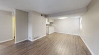 This two-story residence at 1669 Randolph Pl in Memphis, Tennessee offers a practical and well-organized layout across two floors. The main level features an open-concept living room and kitchen combination, where rich hardwood-style flooring flows throughout. The kitchen is outfitted with white shaker cabinets, granite-look countertops, a subway tile backsplash, stainless steel appliances including a refrigerator, electric range, and dishwasher, complemented by a double basin sink. The living room receives natural light through a sliding glass door fitted with vertical blinds. The upper level houses both bedrooms, each finished with plush carpeting and neutral-toned walls. The spacious primary bedroom features a ceiling fan and ample room, while the second bedroom includes a window that brings in natural light. A dedicated closet with built-in shelving provides organized storage. Three bathrooms serve the home, one of which includes a soaking tub and hardwood-style flooring. Textured ceilings are found throughout, and the consistent neutral color palette lends a clean, cohesive aesthetic. The layout is efficiently connected by two staircases and hallways, providing smooth circulation between both levels.