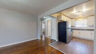 Located at 72 Folly Brook Blvd in Wethersfield, CT, this single-floor unit combines classic charm with modern updates throughout. Rich, deeply polished hardwood floors flow seamlessly across the living, dining, and bedroom spaces, creating a warm and cohesive aesthetic.

The open living and dining area is generously proportioned, bathed in natural light through large windows, and anchored by a contemporary orbital pendant light fixture. The space connects directly to a well-appointed kitchen featuring crisp white shaker-style cabinetry, granite countertops, a subway tile backsplash, stainless steel appliances including a range and refrigerator, and a window above the sink that brings in additional natural light.

The bedrooms are comfortably sized, each finished with the same gleaming hardwood floors, soft neutral-toned walls, and windows that allow ample daylight. Baseboard heating is present throughout the unit. The bathroom has been thoughtfully renovated with large-format floor tiles, a stone-look tile surround in the tub/shower area, and a dark-finished vanity, delivering a clean, contemporary finish.

The layout is efficient and well-connected, offering a comfortable and updated living environment in a convenient Wethersfield location.