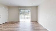Located at 6502 208th St SW in Lynnwood, Washington, this one-bedroom, one-bathroom unit offers a well-designed single-floor layout that maximizes functionality and comfort. The open living room is bright and welcoming, featuring durable wood-look laminate flooring, recessed lighting, a ceiling fan, and a sliding glass door that opens to an outdoor patio, filling the space with natural light and garden views. The kitchen is thoughtfully appointed with grey shaker-style cabinetry, marble-look countertops, a stainless steel double-basin sink, and a stainless steel refrigerator — offering both style and practicality in a compact galley layout. The bedroom is carpeted for warmth and comfort, featuring a sliding-door closet with built-in shelving and a window with blinds that brings in natural light. A dedicated laundry area with a stacked washer and dryer unit and a water heater is conveniently accessible from the bedroom. The full bathroom includes a tub/shower combo with clean white surround, wood-look flooring, and a marble-style vanity. Neutral tones and clean finishes throughout create a cohesive, move-in-ready feel.