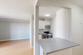 Located at 1400 Ouellette Ave in Windsor, Ontario, this efficiently designed unit offers a thoughtful layout across a single floor. The open-concept kitchen and living area forms the heart of the space, featuring light hardwood-style flooring, neutral grey walls, and large sliding glass doors that flood the room with natural light. The kitchen is equipped with stainless steel appliances, including a range and oven, complemented by crisp white cabinetry, an under-cabinet range hood, and a grey countertop that extends to a peninsula — ideal for casual dining or food preparation. The spacious living area benefits from a wall-mounted TV bracket and a baseboard heating system running beneath the expansive windows. A sliding door leads directly to the private balcony, which features a glass-railed design and offers elevated views of the surrounding Windsor cityscape. The full bathroom is clean and functional, finished with white tile flooring, a tub-shower combination, and a large mirror. A dedicated closet provides additional storage. The unit's modern, minimalist aesthetic throughout makes it a practical and comfortable urban living space in a central Windsor location.