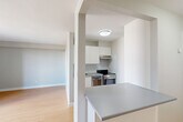 Located at 1400 Ouellette Ave in Windsor, Ontario, this efficiently designed unit offers a thoughtful layout across a single floor. The open-concept kitchen and living area forms the heart of the space, featuring light hardwood-style flooring, neutral grey walls, and large sliding glass doors that flood the room with natural light. The kitchen is equipped with stainless steel appliances, including a range and oven, complemented by crisp white cabinetry, an under-cabinet range hood, and a grey countertop that extends to a peninsula — ideal for casual dining or food preparation. The spacious living area benefits from a wall-mounted TV bracket and a baseboard heating system running beneath the expansive windows. A sliding door leads directly to the private balcony, which features a glass-railed design and offers elevated views of the surrounding Windsor cityscape. The full bathroom is clean and functional, finished with white tile flooring, a tub-shower combination, and a large mirror. A dedicated closet provides additional storage. The unit's modern, minimalist aesthetic throughout makes it a practical and comfortable urban living space in a central Windsor location.
