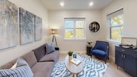 This thoughtfully designed single-floor residence offers a cohesive blend of modern finishes and comfortable living spaces. The open-concept kitchen is a standout feature, equipped with stainless steel appliances including a refrigerator, range, microwave, and dishwasher. Sleek, light-toned cabinetry lines the walls, complemented by quartz countertops, open shelving, and a central island with bar seating — ideal for both meal preparation and casual dining. Pendant lighting adds a contemporary touch overhead.

The living room is a warm and inviting retreat, featuring light hardwood-style flooring, neutral walls, and large windows that flood the space with natural light and offer pleasant views of surrounding foliage. The bedroom spaces are comfortably scaled, each with soft carpeting, windows providing outdoor views, and clean, neutral finishes. One bedroom features built-in USB ports, adding a modern convenience. A spacious walk-in closet provides generous storage with multiple hanging rods and shelving.

The full bathroom is clean and functional, featuring a combination tub and shower, a single vanity with a light wood finish, and wood-style tile flooring. Throughout the residence, a consistent neutral palette and modern design sensibility create a calm, cohesive atmosphere.