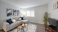 This single-floor unit offers a thoughtfully designed layout across several well-defined living spaces. The living room serves as the heart of the home, featuring durable wood-style flooring, a textured ceiling, and a window fitted with blinds that allows natural light to fill the room. Neutral gray walls provide a versatile backdrop throughout.

The kitchen is efficiently designed with ample white cabinetry accented by warm wood trim, marble-style countertops, and stainless steel appliances including a refrigerator, dishwasher, and electric range. A ceiling fan with light fixture overhead and wood-style flooring complete the space, which connects seamlessly to a dining area with room for a small table.

The primary bedroom features plush carpet flooring, a window with blinds for natural light, and a textured ceiling, offering a comfortable and quiet retreat. A secondary room with carpet flooring and a window provides flexible use as an additional bedroom or home office.

The bathroom includes a full tub and shower combo, wood-style flooring, and clean, functional fixtures. Throughout the unit, consistent gray-toned walls and neutral finishes create a cohesive, modern aesthetic that is both practical and inviting.