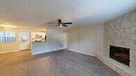 Located at 348 Tall Oaks Dr in Conyers, GA, this well-appointed 2-bedroom, 2-bathroom single-story home offers a thoughtfully designed layout across a comfortable floor plan. The living room serves as the heart of the home, anchored by a striking floor-to-ceiling stacked stone fireplace with a raised hearth, complemented by wood-look laminate flooring and a ceiling fan. Natural light filters in through window treatments throughout the space. The galley-style kitchen features white cabinetry, granite countertops, stainless steel appliances including a dishwasher and range, and a double sink — all finished with light wood-look flooring. A dedicated utility room sits conveniently adjacent. Both bedrooms are carpeted and equipped with ceiling fans, offering a cozy retreat with natural light from well-placed windows. The spacious primary bedroom includes ample room and connects to a hallway leading to the bathrooms. Each bathroom is outfitted with white cabinetry, granite countertops, and a tub-shower combination with a curved curtain rod. Two closets provide generous storage. A private patio rounds out this home, adding comfortable outdoor living space.