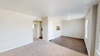 Located at 3001 E League City Pkwy in League City, Texas, this single-story 2-bedroom, 2-bathroom residence offers a practical and comfortable layout. The combined living and dining area forms the heart of the home, featuring dark hardwood-style flooring that transitions to soft carpet in the living space. Large windows along the front of the unit flood the area with natural light and provide views of the surrounding neighborhood. A pass-through opening connects the living and dining area to the kitchen, enhancing the sense of openness. The galley-style kitchen is well-equipped with white cabinetry, dark countertops, a black electric range, a refrigerator, a dishwasher, and a stainless steel sink — all set atop matching hardwood-style flooring. A hallway leads from the main living area to both bedrooms and bathrooms. The primary bedroom is a comfortable size, featuring plush carpet and a dedicated closet. The secondary bedroom also features carpet and a window for natural light. Three closets throughout the unit provide ample storage. Both bathrooms are finished with classic white fixtures, including a tub-shower combination. The overall aesthetic is clean and neutral, with a light color palette throughout.