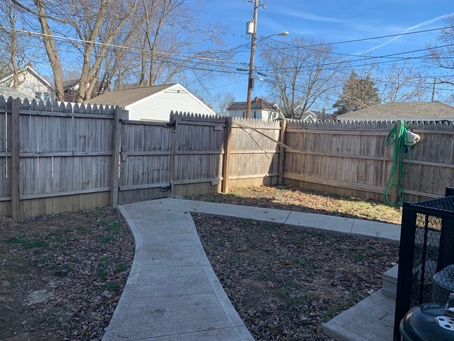 Patio trasero cercado de 1,80 m. Estacionamiento para autos detrás de la cerca. - 672 Stewart Ave
