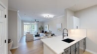Located at 2304 Stillbrook Ln in Princeton, NJ, this well-appointed one-bedroom, one-bathroom residence offers a cohesive, modern aesthetic across its single floor. The open-concept living, dining, and kitchen area forms the heart of the home, bathed in natural light from large sliding glass doors that lead to a private balcony with outdoor views. Crown molding and light hardwood flooring run throughout, lending an air of refined continuity. The living area features a ceiling fan and generous wall space, while the dedicated dining nook comfortably accommodates a full table setting. The kitchen is outfitted with two-tone cabinetry — white uppers and gray lowers — paired with crisp white quartz countertops, a black undermount sink with a matte black faucet, a subway tile backsplash, and a full suite of stainless steel appliances. The spacious primary bedroom offers two windows with outdoor views, a dedicated closet, and access to additional storage. The bathroom features a white vanity with quartz countertop, a soaking tub with shower, and sleek matte black hardware and fixtures throughout. A dedicated laundry room houses a full-size, side-by-side washer and dryer. Three closets provide ample storage throughout the residence.