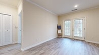 Located at 137 Rolling Marsh Ln in Hardeeville, SC, this one-bedroom, one-bathroom unit offers a thoughtfully designed single-floor layout that maximizes functionality within a compact footprint. Crown molding accents the living room and kitchen, adding a refined touch to the neutral, warm-toned walls that carry throughout the space.

The living room is a bright, open area finished with light gray wood-look flooring and fitted with French doors that allow natural light to flow in while providing access to the outdoors. Crown molding and recessed lighting enhance the polished feel of this central gathering space.

The kitchen features rich, warm-toned cabinetry paired with granite-style countertops, a stainless steel appliance suite including a refrigerator, range, microwave, and dishwasher, and the same light wood-look flooring that ties the main living areas together cohesively.

The bedroom offers a comfortable, carpeted retreat with a large window providing natural light and outdoor views, along with a closet fitted with louvered bi-fold doors for convenient storage.

The bathroom is clean and functional, with a wood-toned vanity, a large mirror, and a shower-tub combination. Light wood-look flooring continues the consistent aesthetic seen throughout the unit.